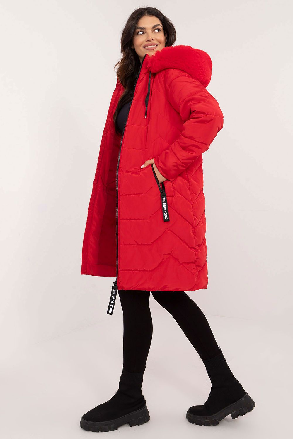 Woman wearing a red Elvarra quilted winter down coat with detachable hood, showcasing modern autumn and winter fashion style.