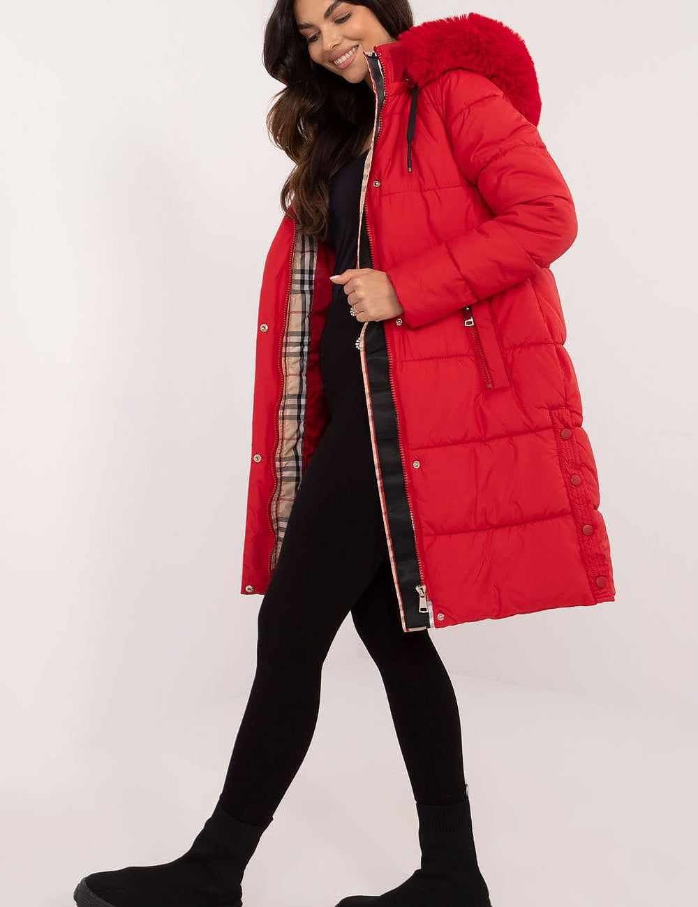 Woman wearing a red Arden Quilted Longline Winter Jacket with detachable hood and fur trim, offering warmth and style for winter.