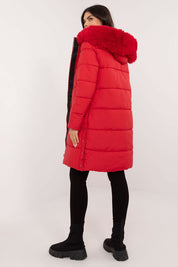Woman wearing red Arden Quilted Longline Winter Jacket with detachable fur trim hood, showcasing autumn and winter fashion.