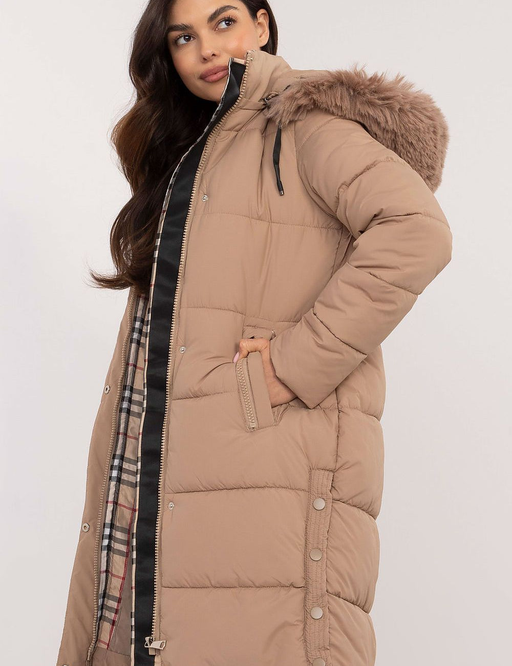 Woman wearing Arden Quilted Longline Winter Jacket with detachable hood and fur trim, showcasing warmth and style for winter.