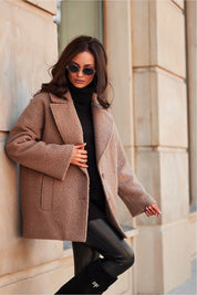 Woman wearing Lurevia Quilted Winter Jacket with sunglasses on a city street, showcasing stylish winter fashion.