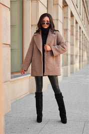 Woman wearing stylish winter jacket with relaxed shoulders and structured collar, posing outdoors.