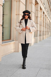 Woman wearing a stylish beige quilted button-up jacket with classic collar and black outfit, walking confidently on a city street.