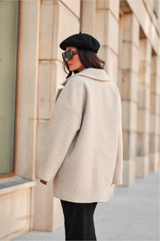 Elegant woman's beige jacket with classic collar, worn outdoors with a black beret, highlighting a stylish and versatile outerwear look.