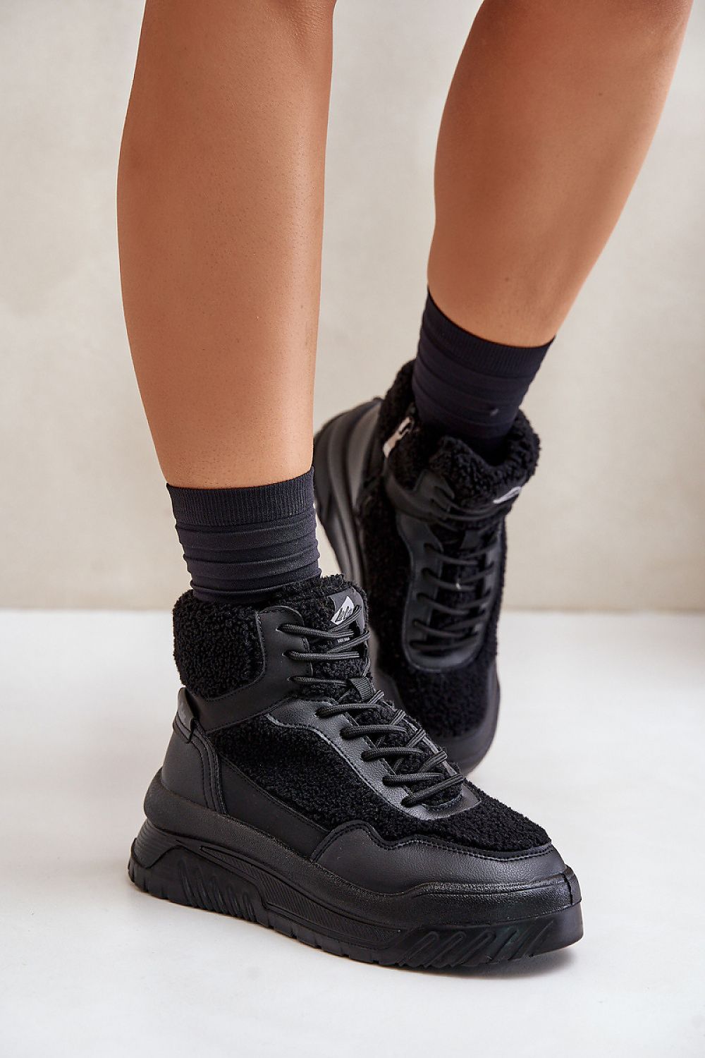 Valmara shearling high-top sneakers with faux sheepskin trim and platform sole, featuring lace and zipper closure for winter wear.