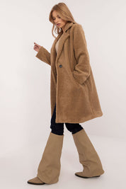 Woman wearing Elantra pre-knee winter coat, showcasing a cozy, elegant style, ideal for autumn and winter seasons.