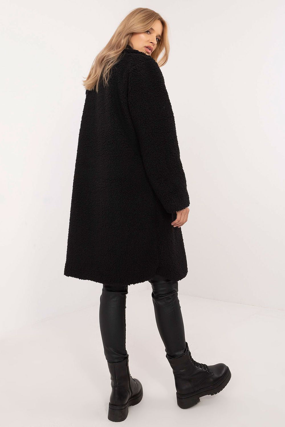 Woman wearing black Elantra pre-knee winter coat paired with leather leggings and boots, showcasing a stylish and elegant winter look.