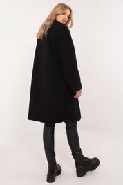 Woman wearing black Elantra pre-knee winter coat paired with leather leggings and boots, showcasing a stylish and elegant winter look.