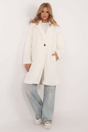 Woman wearing Elantra pre-knee winter coat in white, showcasing elegant design and comfort, paired with jeans and casual shoes.