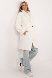 Woman wearing Elantra pre-knee winter coat in white, paired with casual jeans and sneakers, showcasing elegant and versatile design.