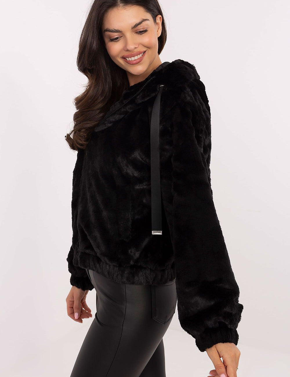 Woman wearing Corvalyn Hooded Teddy Bear Zip Jacket with soft texture, black in color, featuring a hood and adjustable waist ties for a cozy fit.