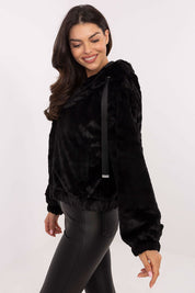 Woman wearing Corvalyn Hooded Teddy Bear Zip Jacket with soft texture, black in color, featuring a hood and adjustable waist ties for a cozy fit.