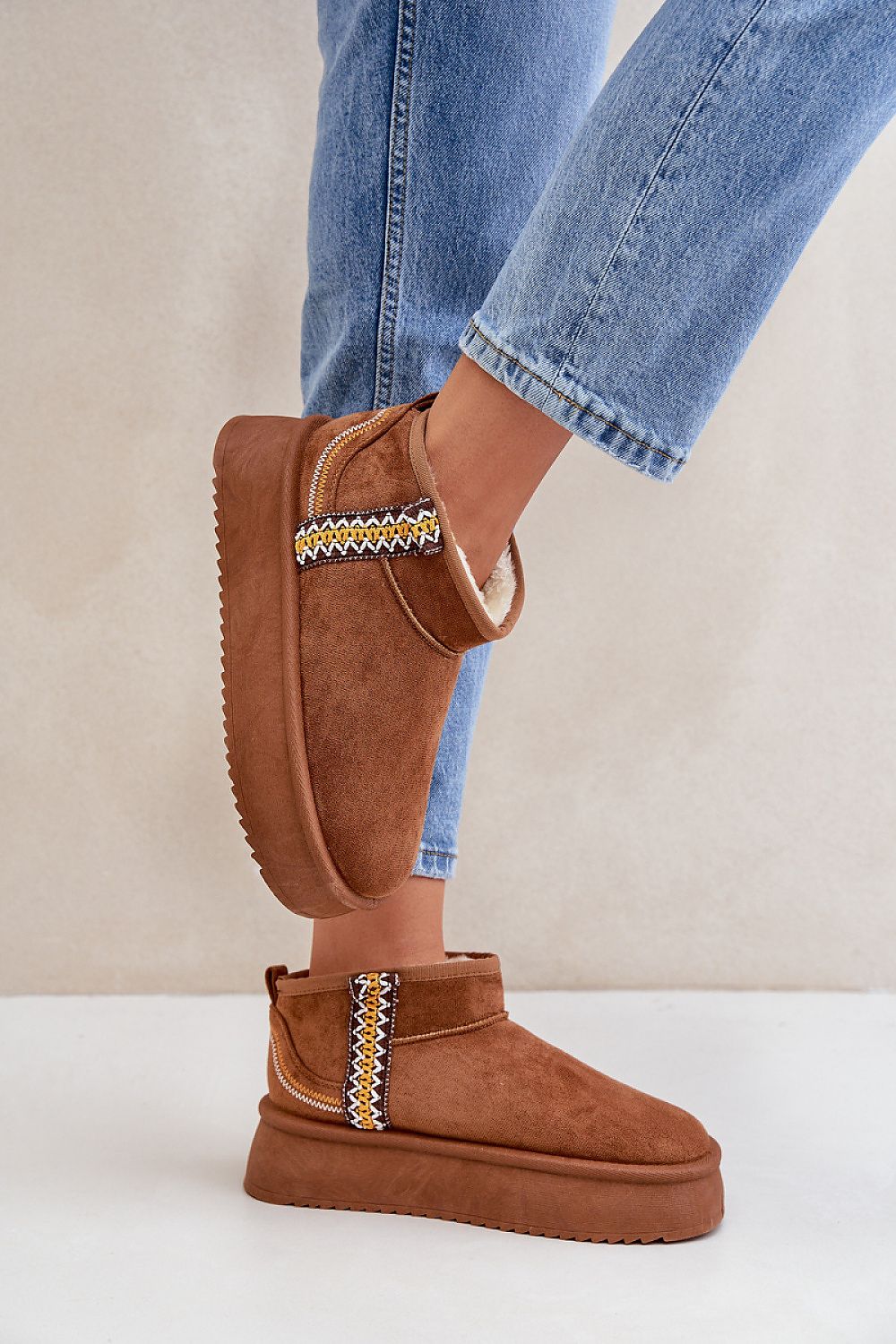 Woman wearing Azmira Aztec Platform Snow Boots with eco suede and fur lining, featuring Aztec pattern and 4 cm platform for winter warmth