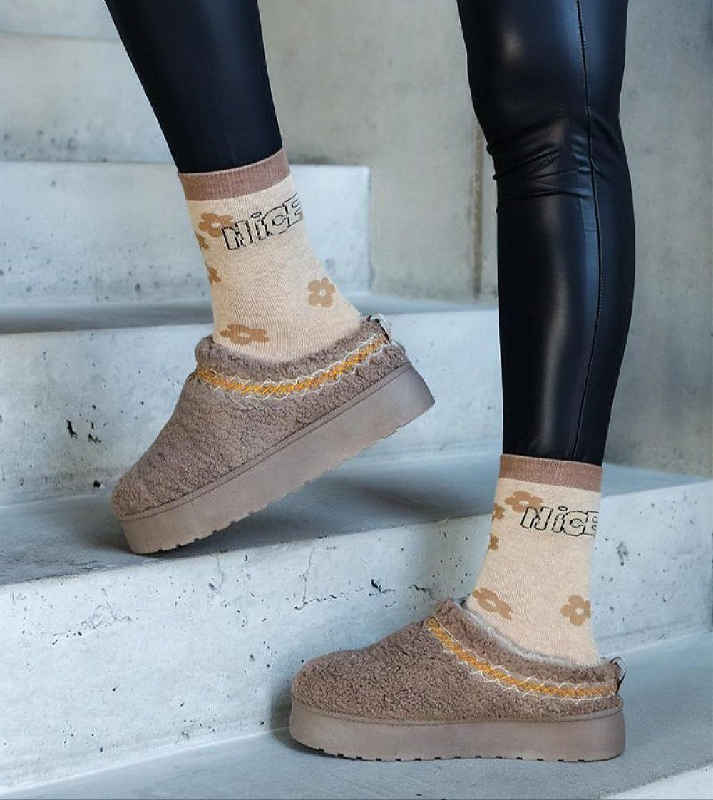 Person wearing Tavelya Embroidered Winter Snow Boots with floral socks, showcasing slip-on design, rubber sole, and low heel.