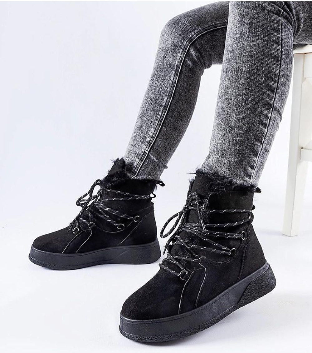 Person wearing Darnelle Platform Winter Snow Boots in black, featuring slip-on design, insulated lining, and water-resistant eco leather.