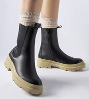 Vereliane ankle boots in black vegan leather with olive rubber sole, featuring a side zipper and flat heel for comfort and style.