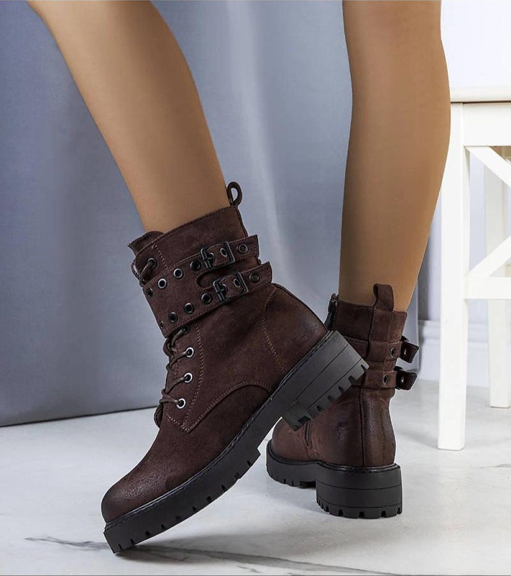 Woman wearing Ardevra insulated ankle boots with suede-look texture, bold straps, and thick treaded sole, ideal for autumn and winter.
