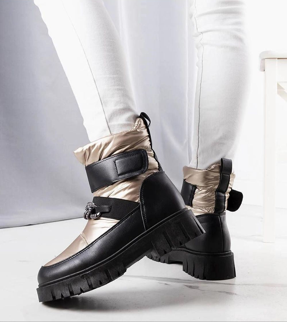 Solvara winter chain snow boots with glossy finish, metallic chain, waterproof panels, and plush faux fur lining. Ideal for snowy weather.