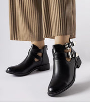 Dravelle cut-out ankle boots with dual buckles in black eco leather, featuring rounded toe and edgy design for stylish comfort.