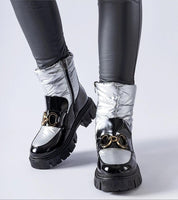 Nevelle insulated lacquered snow boots with black and silver tones, featuring a sturdy rubber sole and stylish design for winter wear.