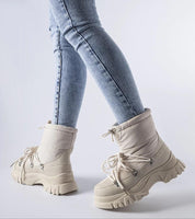 Person wearing Eldarien Lace-Up Snow Boots with insulated design and waterproof rubber outer, perfect for winter conditions.
