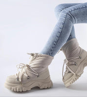 Eldarien Lace-Up Snow Boots in beige with rugged sole, shown with jeans. Ideal for city wear and snowy conditions, featuring waterproof design.