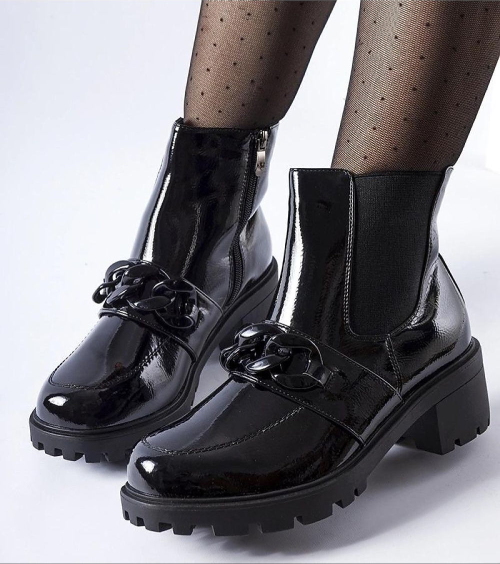 Velandra Glossy Buckle Boots in patent-effect eco leather with metal buckle, insulated for warmth, on a model with patterned tights.
