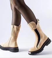 Woman wearing Nolara Insulated Mid-Heel Boots with fishnet tights, showcasing warm, stylish winter footwear with a medium height heel and zipper.