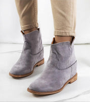 Gray slip-on boots with hidden heel, featuring soft suede texture and minimalist design, perfect for versatile styling in cooler weather.