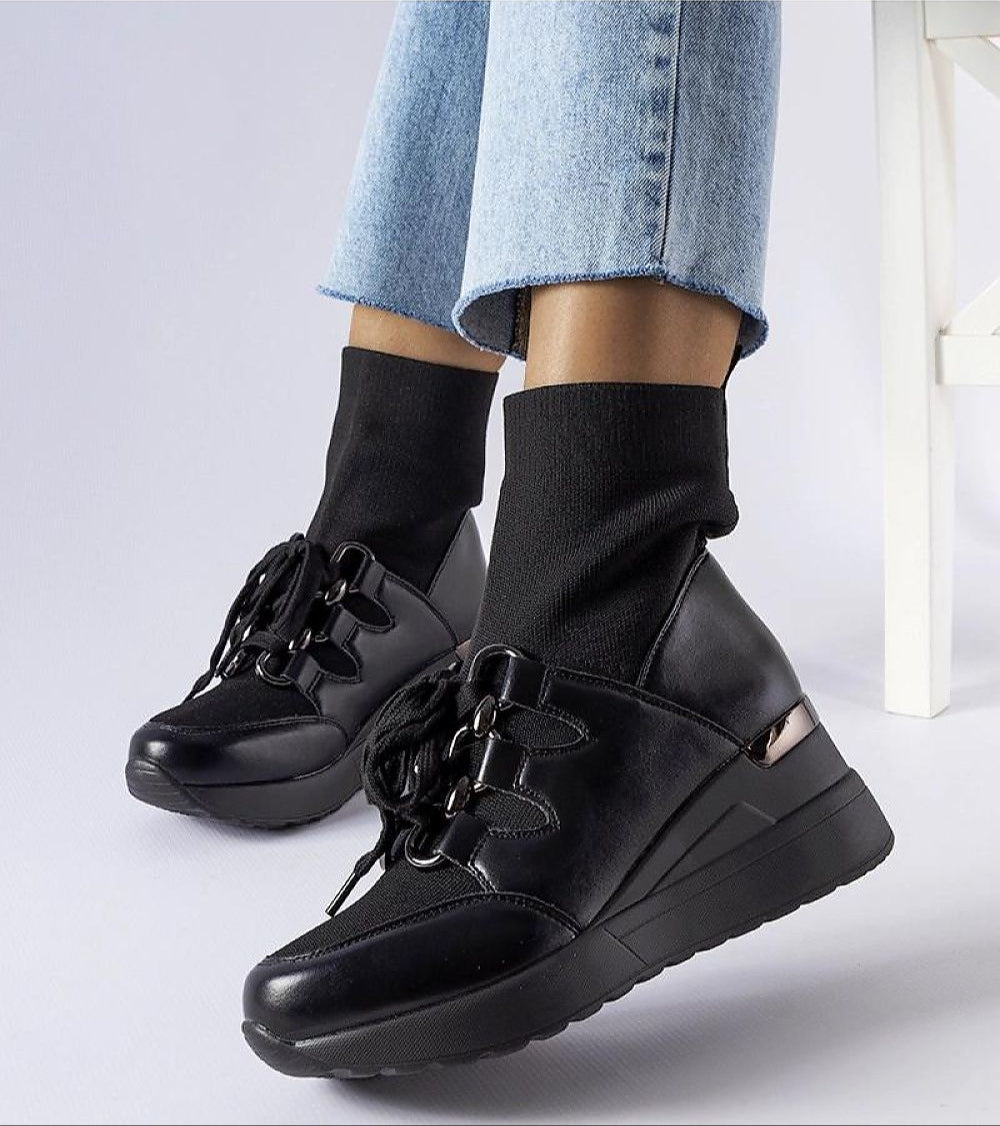 Black platform buskin boots with a sleek slip-on design, 6 cm heels, rounded toe, and sturdy rubber sole for traction in any weather.