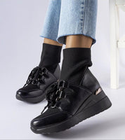 Black platform buskin boots with a sleek slip-on design, 6 cm heels, rounded toe, and sturdy rubber sole for traction in any weather.