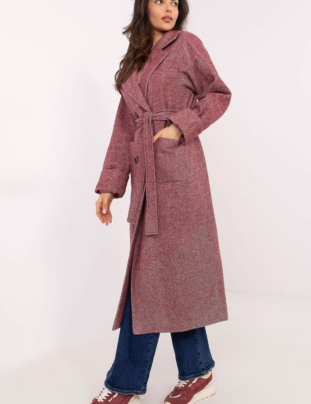 Woman wearing Selvarane Long Double-Breasted Wool Coat with fine stripe pattern and belted waist, styled with casual denim and sneakers.