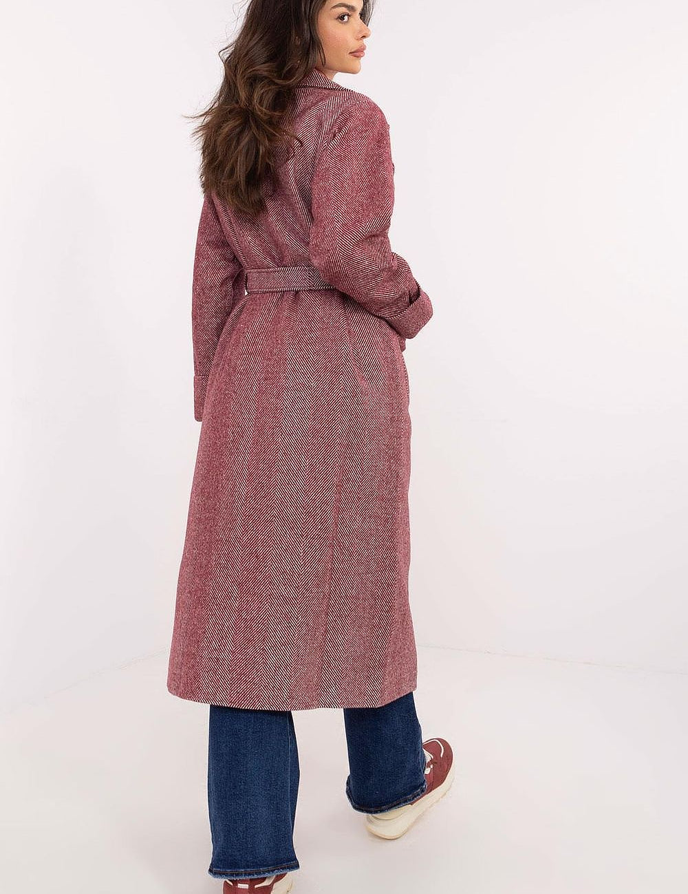Woman wearing Selvarane Long Double-Breasted Wool Coat with fine stripes, belted waist, and side pockets, shown from the back.