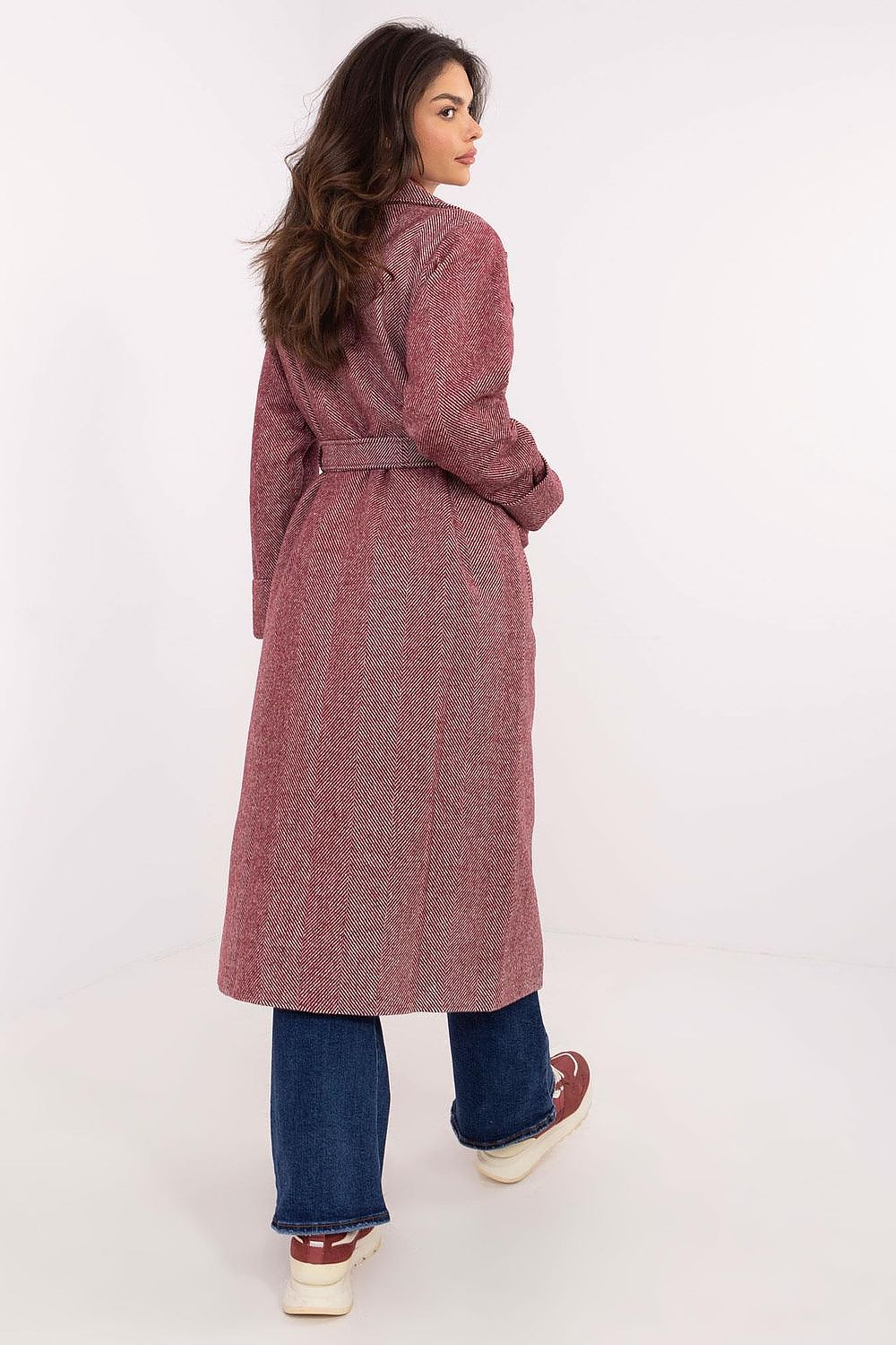 Woman wearing Selvarane Long Double-Breasted Wool Coat with fine stripes, belted waist, and side pockets, shown from the back.