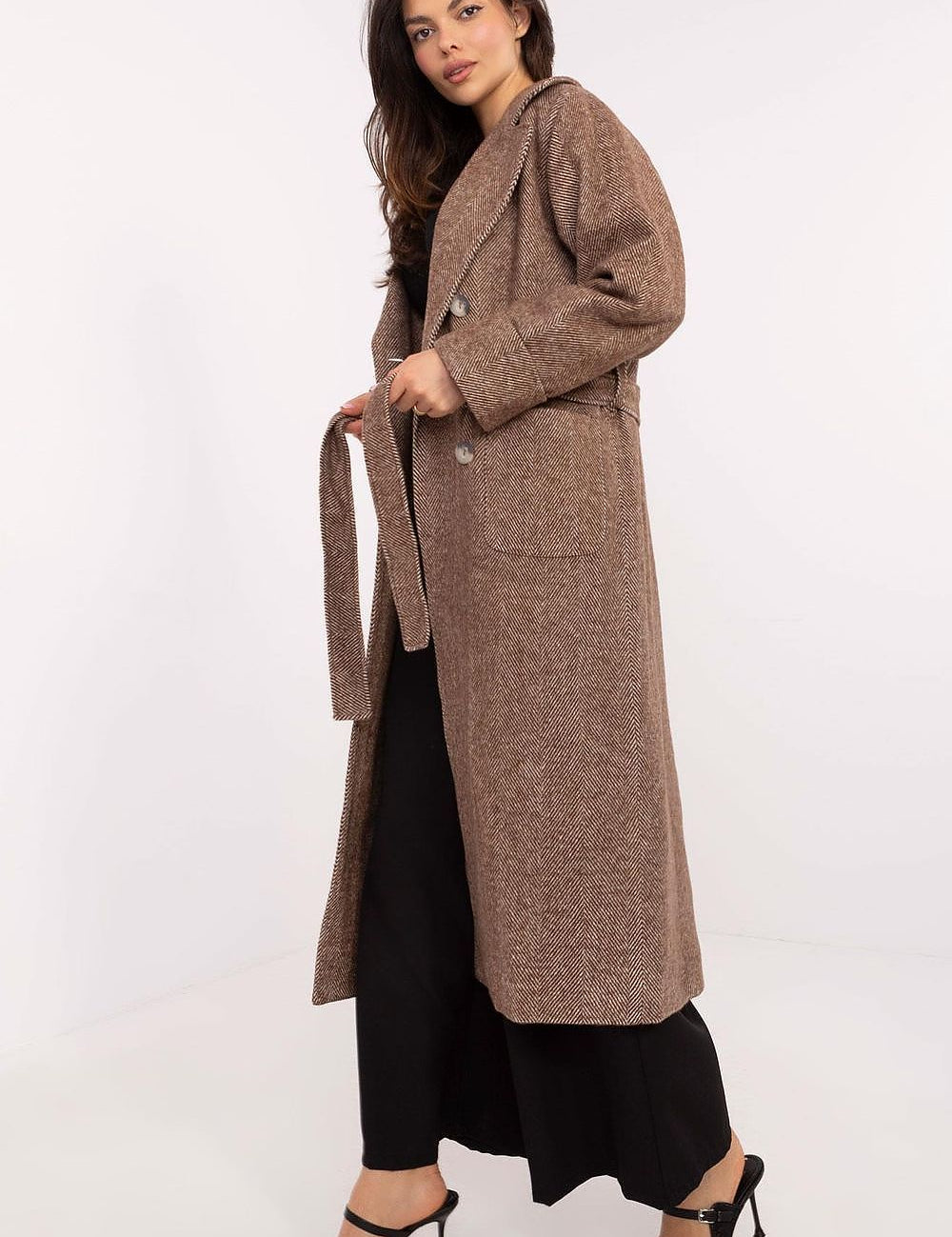 Woman wearing a brown Selvarane long double-breasted wool coat with belted waist and stripe pattern for transitional seasons.