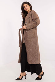 Woman wearing a brown Selvarane long double-breasted wool coat with belted waist and stripe pattern for transitional seasons.