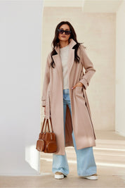 Model wearing Loravinne Belted Long-Sleeve Lined Coat, styled with sunglasses, bag, and jeans for a chic, everyday look.