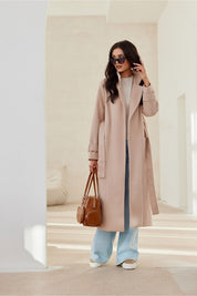 Model wearing Loravinne Belted Long-Sleeve Lined Coat with casual jeans, holding a handbag, showcasing the coat's elegant silhouette.