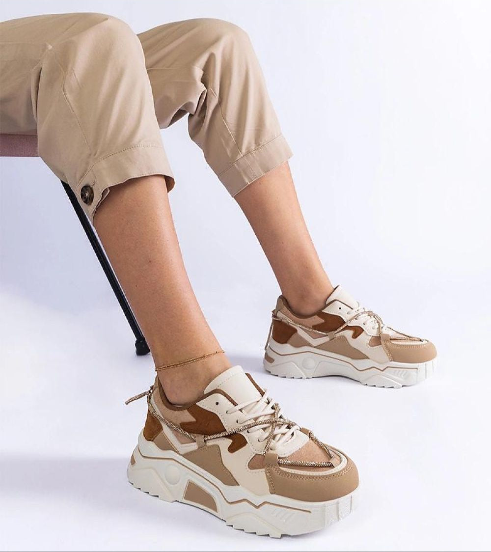 Person wearing Thalvyn Crystal-Tied Brown Sneakers with crystal-accented laces and white rubber sole, showcasing casual style.