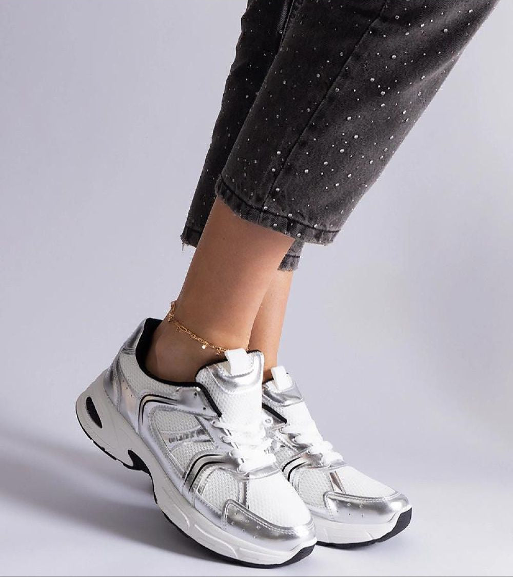 Person wearing Melvyna White Motion Sneakers with eco leather upper and gray sole, showcasing style and comfort in everyday wear.