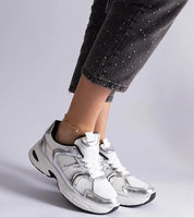 Person wearing Melvyna White Motion Sneakers with eco leather upper and gray sole, showcasing style and comfort in everyday wear.