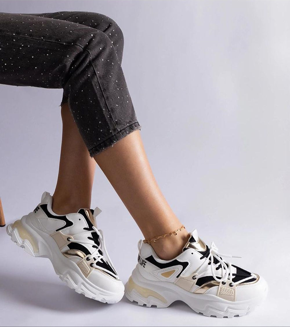 Person wearing Selvyna Contrast Sport Sneakers with black and white color blocking and a supportive 5cm sole, styled with dark pants.