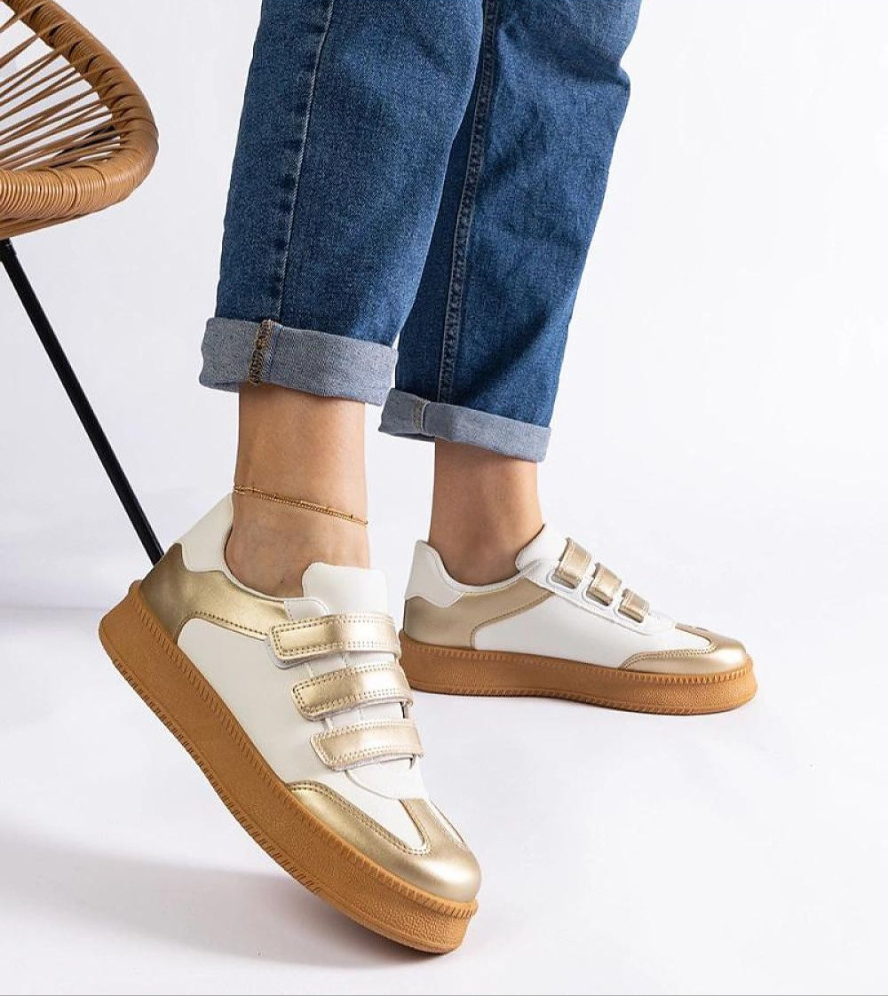 Person wearing Elurea Gold Velcro Street Sneakers in eco leather with golden sheen, brown rubber sole, showcasing casual street style.