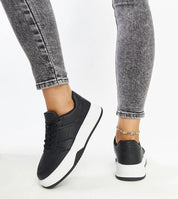Kaedira Bold Platform Sneakers with elevated black sole and lace-up design, worn with ankle jeans, showcasing urban style and comfort.