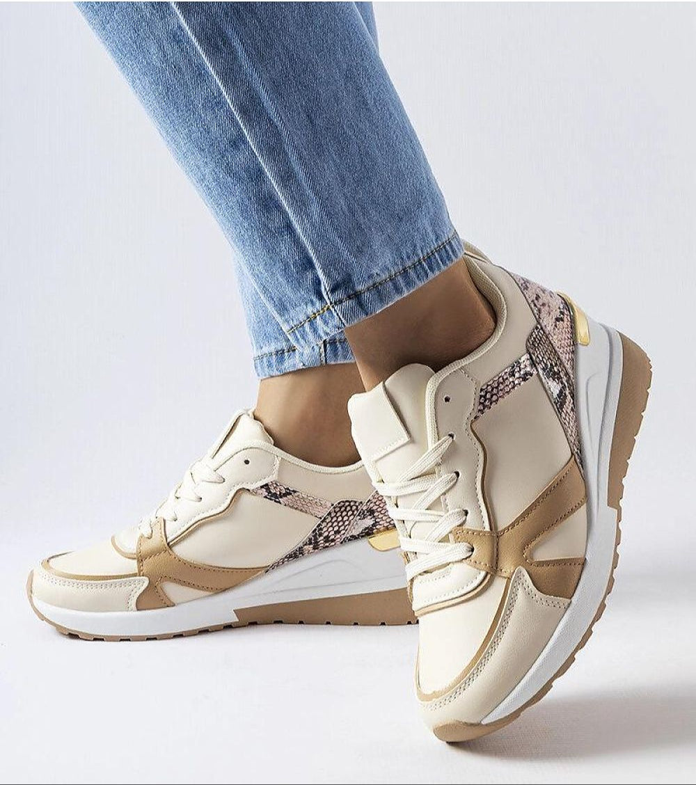 Person wearing beige lace-up wedge sneakers with jeans, featuring eco-friendly faux suede and a 5.5 cm wedge sole for style and comfort.