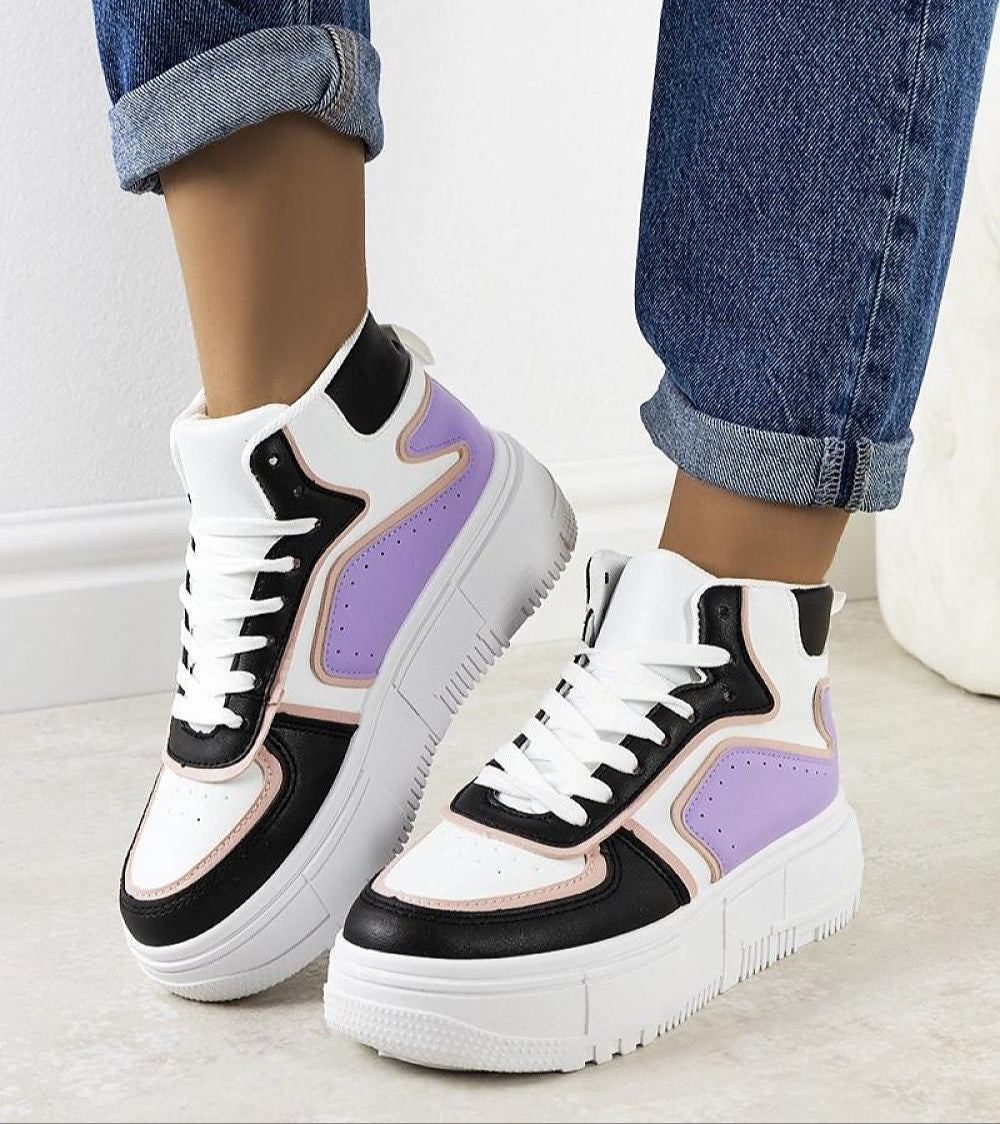 Woman wearing Darellin ankle-high lace sneakers with sculpted sole and eco leather upper, paired with cuffed jeans on a light floor.