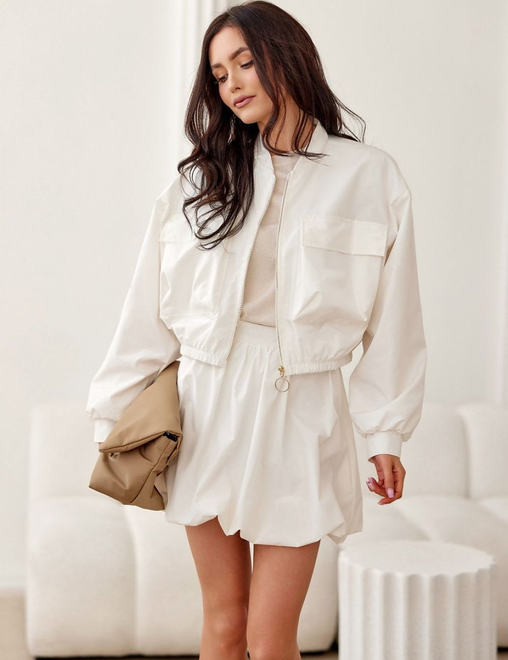 Woman wearing Valserra lined bomber jacket with a casual dress, showcasing the minimalist design and side flap pockets.