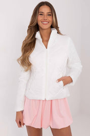 Woman wearing Morvianne Quilted Zip-Front Jacket in white, showcasing its durable nylon and lightweight design, paired with pink skirt.