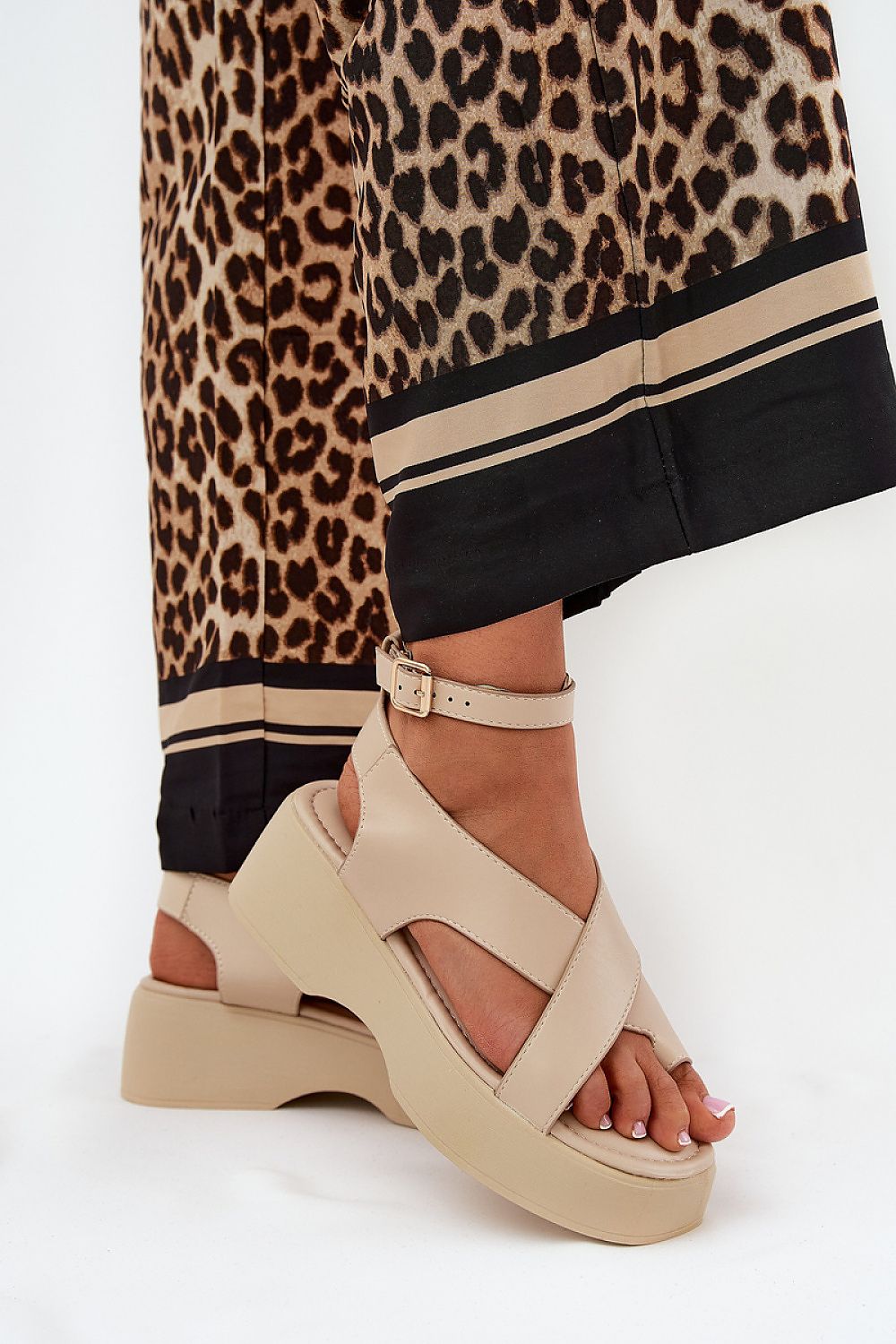 Lirianne Platform Buckle Sandals in eco leather with wedge platform and ankle strap, styled with leopard print pants for a chic look.
