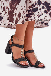 Model wearing Marinia Braided Column-Heel Sandals with gold accents and a 9 cm heel, styled with a patterned dress, ideal for summer events.